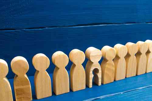 © Andrii Yalanskyi - stock.adobe.com Holzfiguren in einer Reihe, eine hat ein ausgeschnittenes Kind